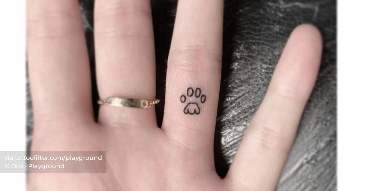 Minimalist dog paw tattoo on the finger.