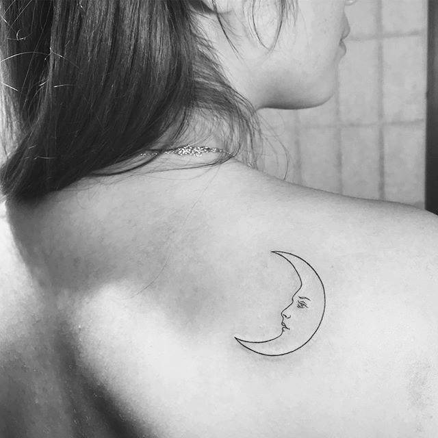 Crescent moon tattoo on the right shoulder blade.