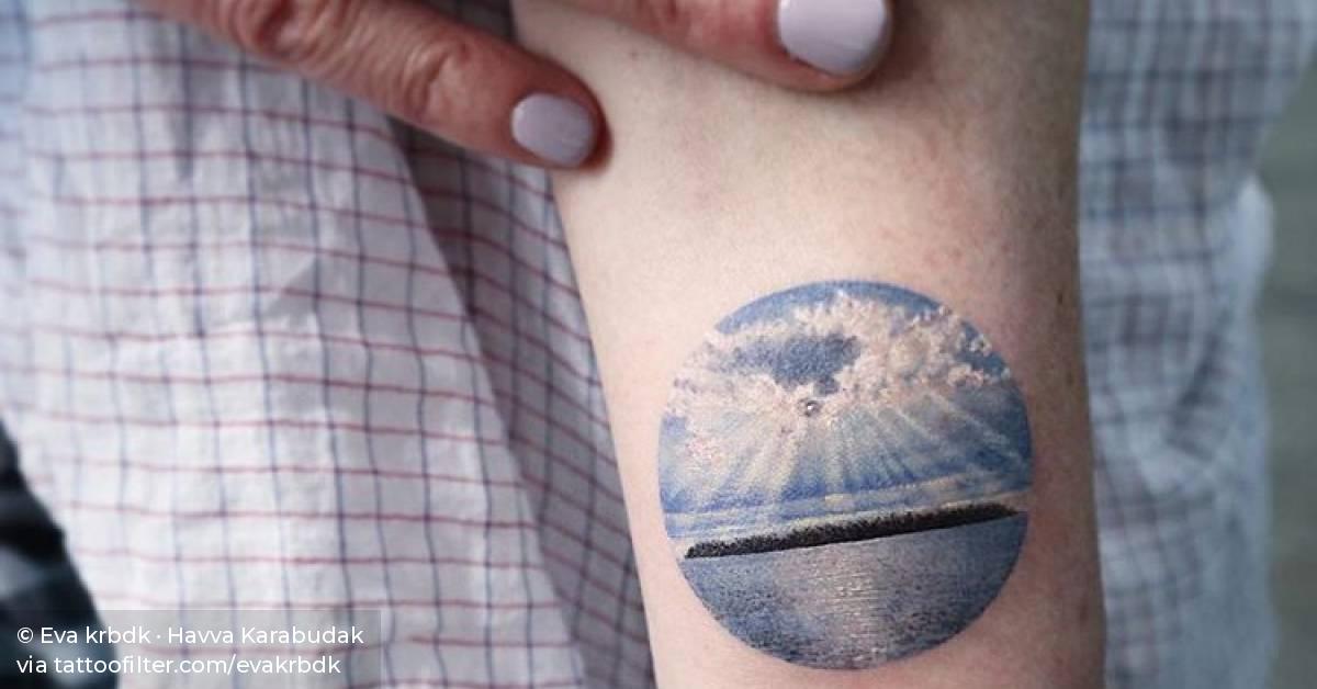 Island landscape tattoo on the inner forearm.