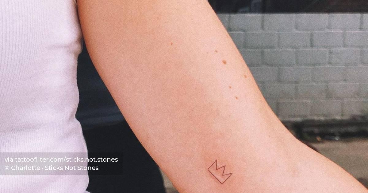 Hand poked crown tattoo located on the inner arm.