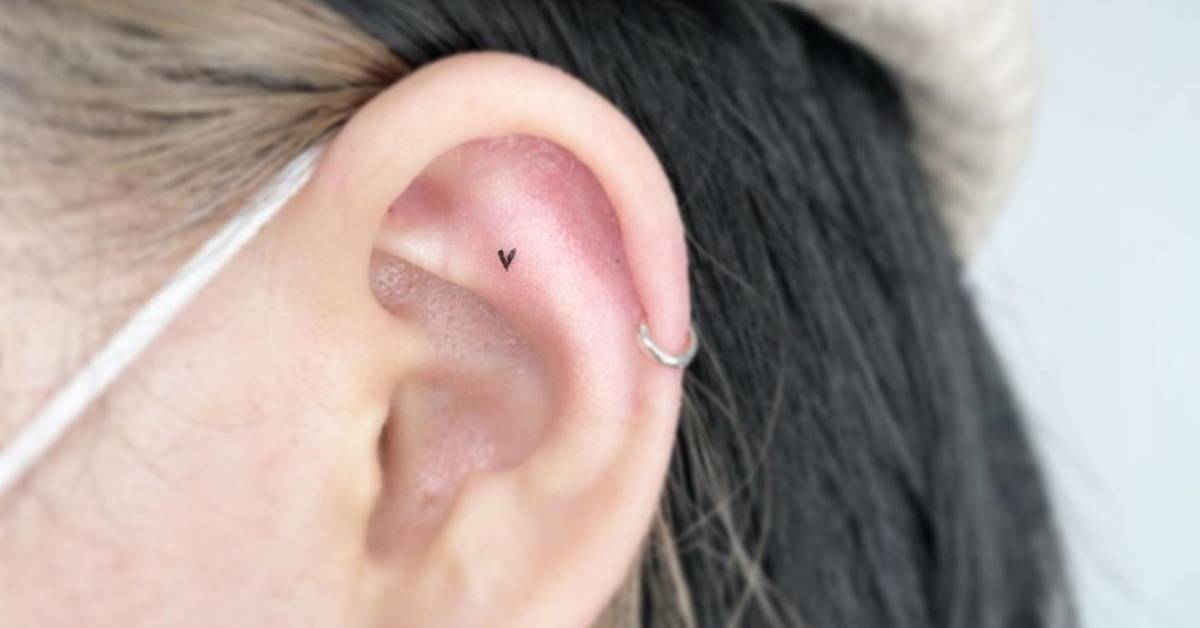 Micro heart tattoo located on the ear, minimalistic