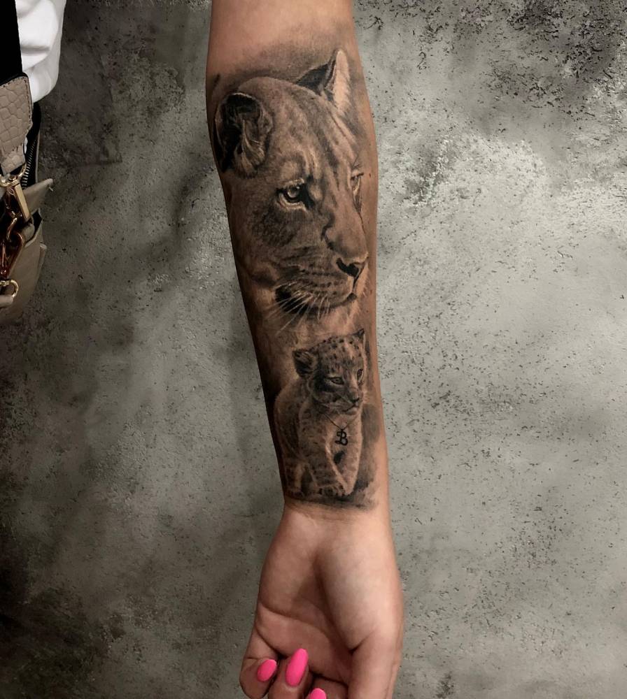 Black And Grey Lioness And Cub Tattoo Located On The
