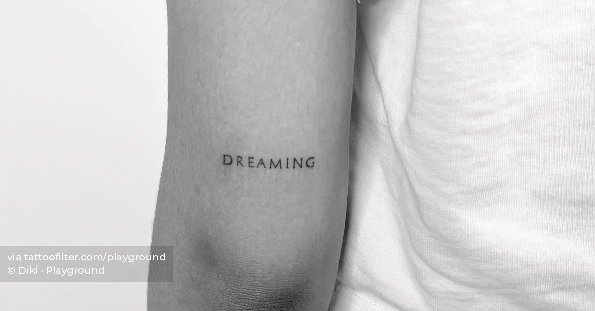 Tattoo of the word "dreaming" located on the tricep.
