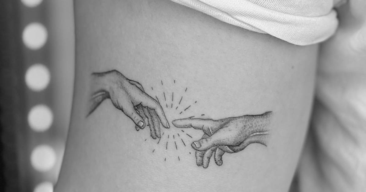 Hands from 'The Creation of Adam" tattooed on the