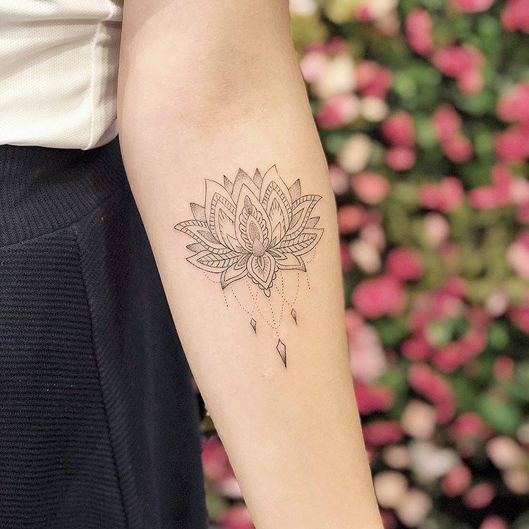 Lotus flower tattoo on the left inner forearm.