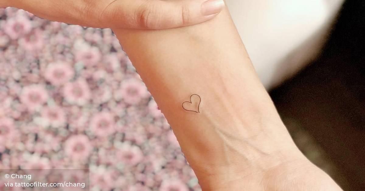 Minimalist heart tattoo on the wrist.