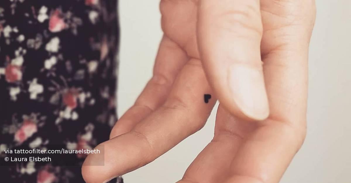Tiny minimalistic heart tattoo located on the finger.