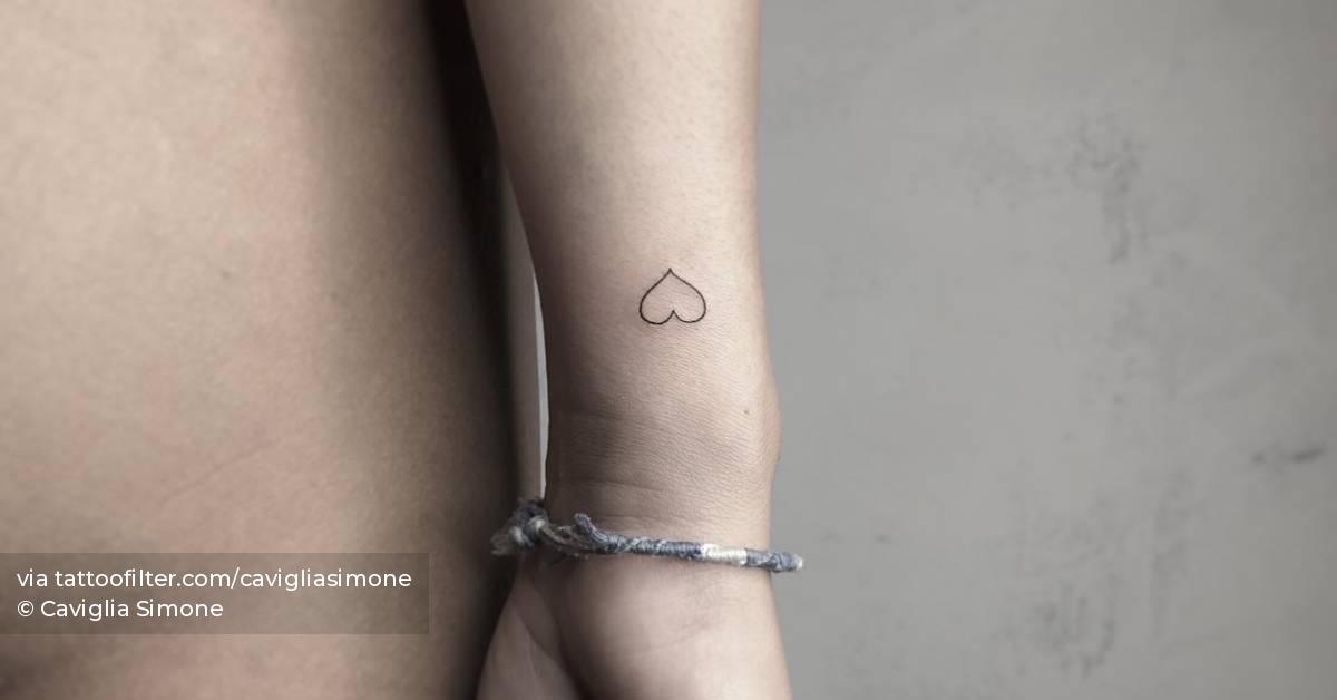 Minimalistic heart tattoo located on the wrist.