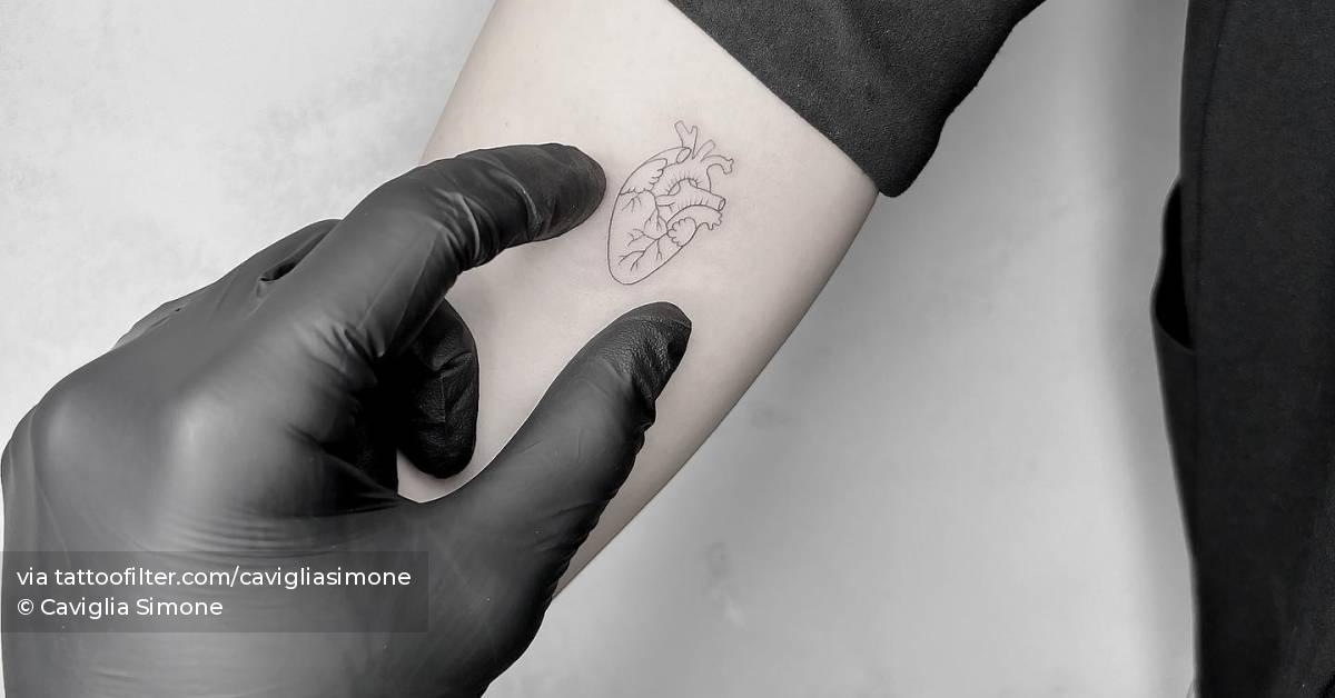 FIne line anatomical heart tattooed on the inner arm.