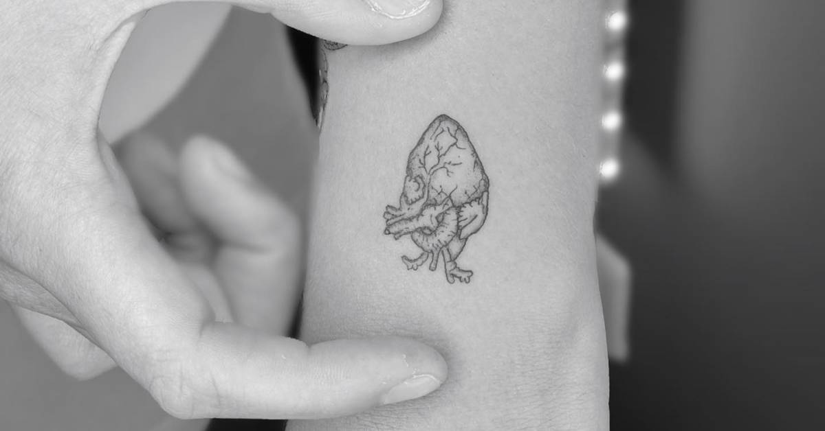 Fine line anatomical heart tattoo located on the wrist.
