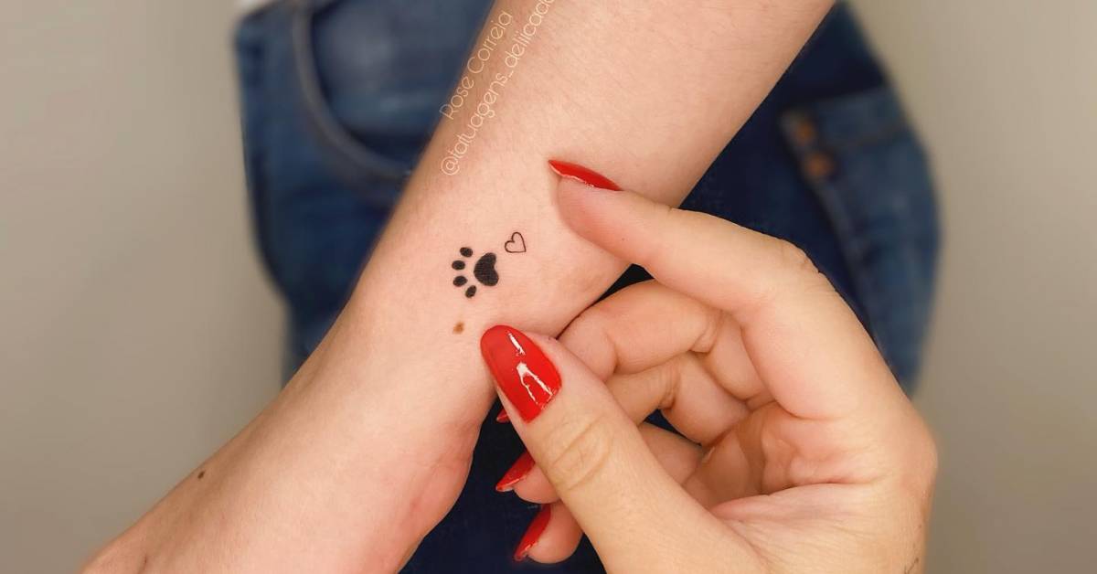 Minimalistic style dog paw tattoo located on the wrist.