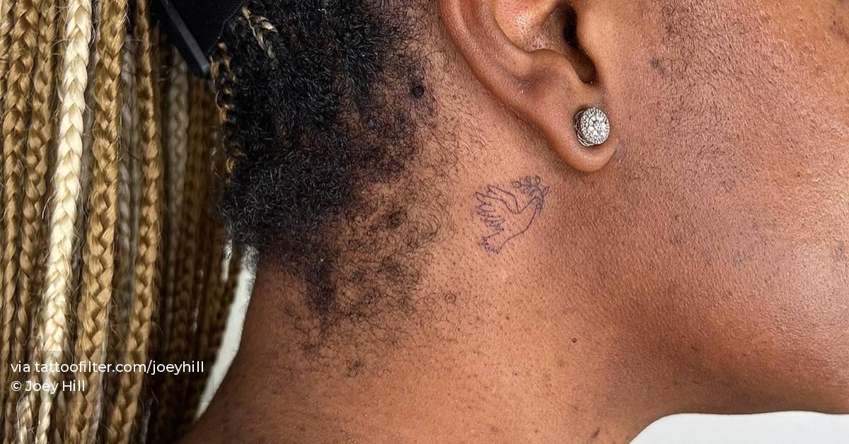 Fine line dove tattoo located behind the ear.