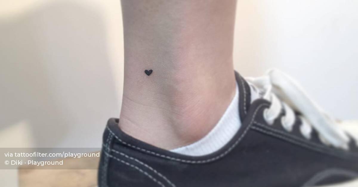 Tiny minimalistic heart tattoo located on the ankle.