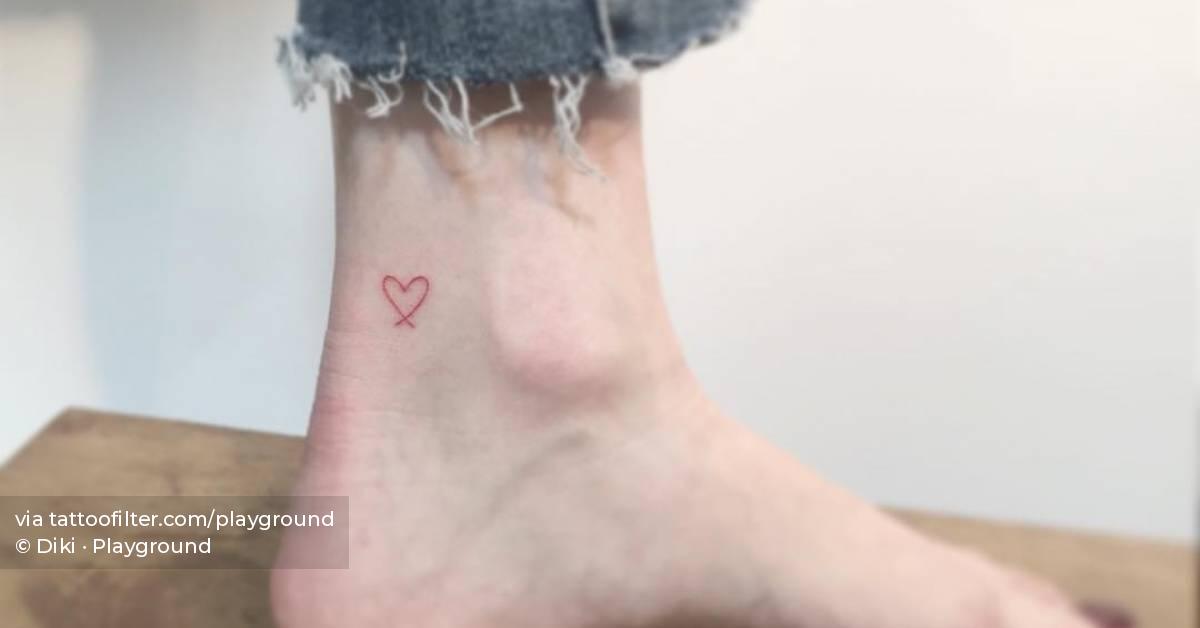 Minimalistic red heart tattoo located on the ankle.