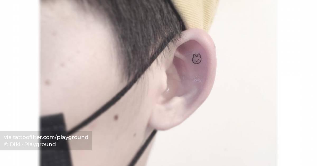 Tiny minimalistic rabbit tattoo located on the ear.