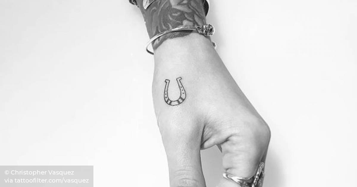 Horseshoe tattoo on the left hand.