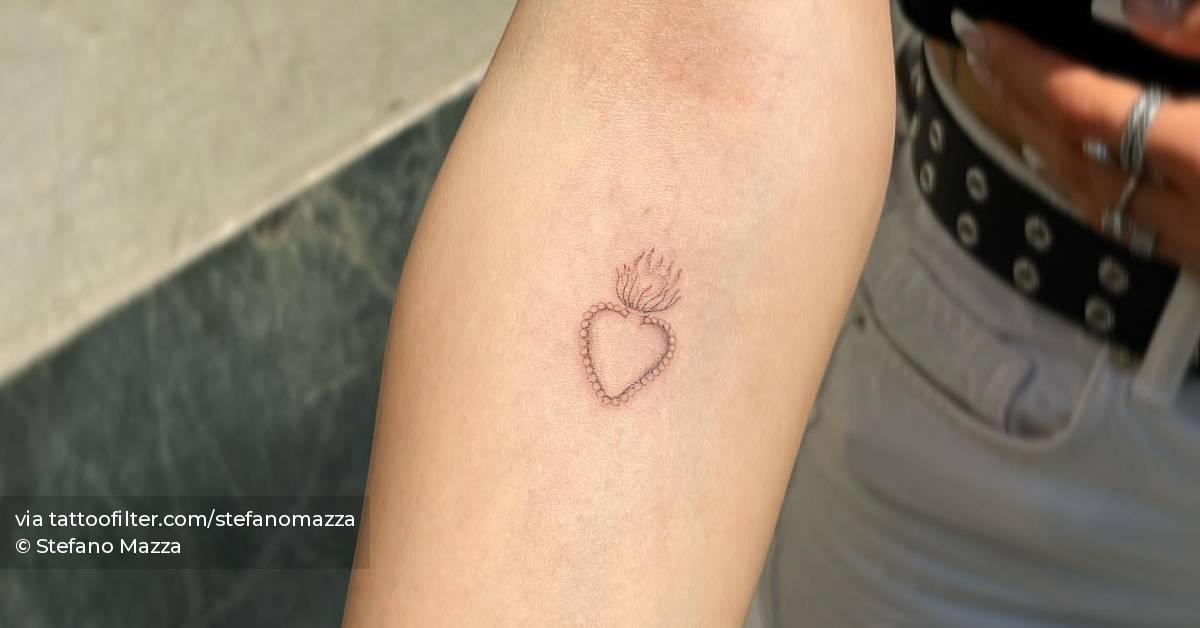 Single needle sacred heart tattoo located on the