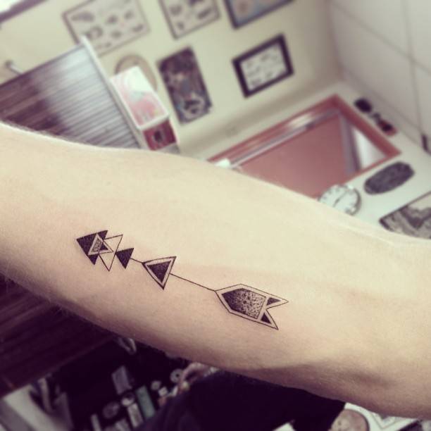 Arrow tattoo on the inner forearm.