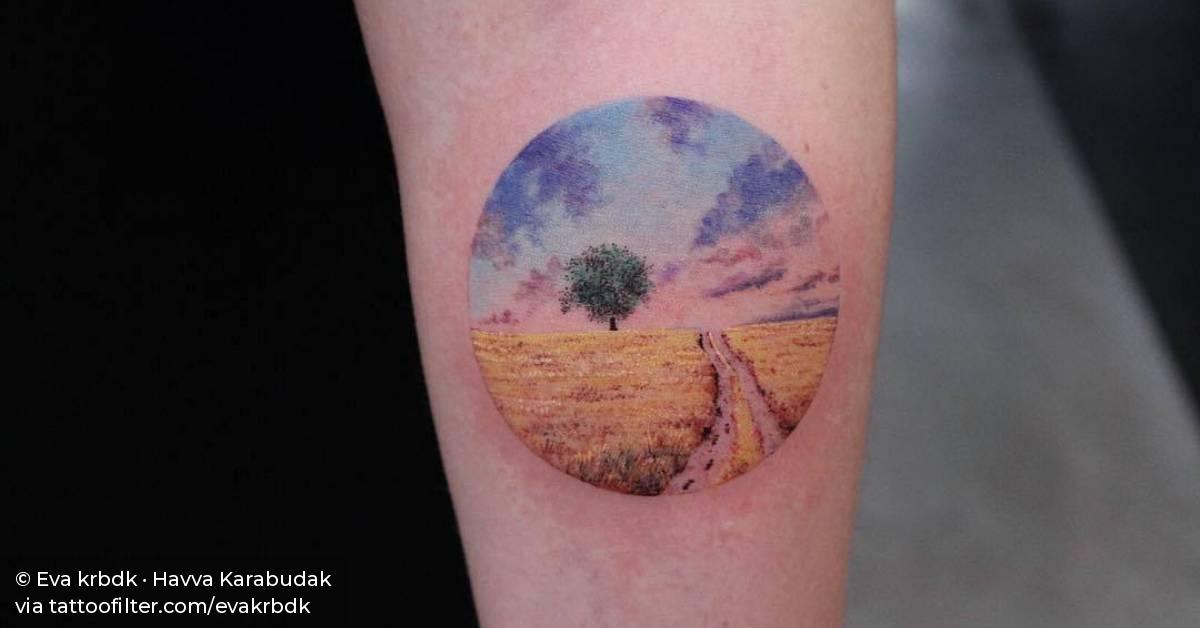 Landscape circle tattoo on the inner forearm.