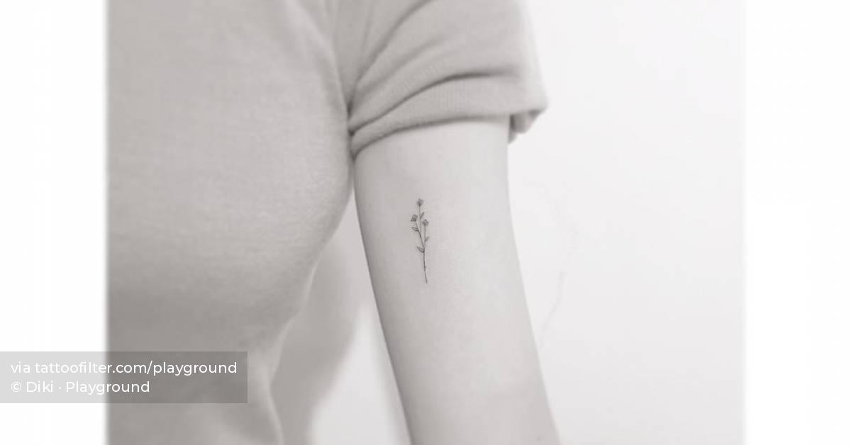Fine line flower tattoo located on the inner arm.