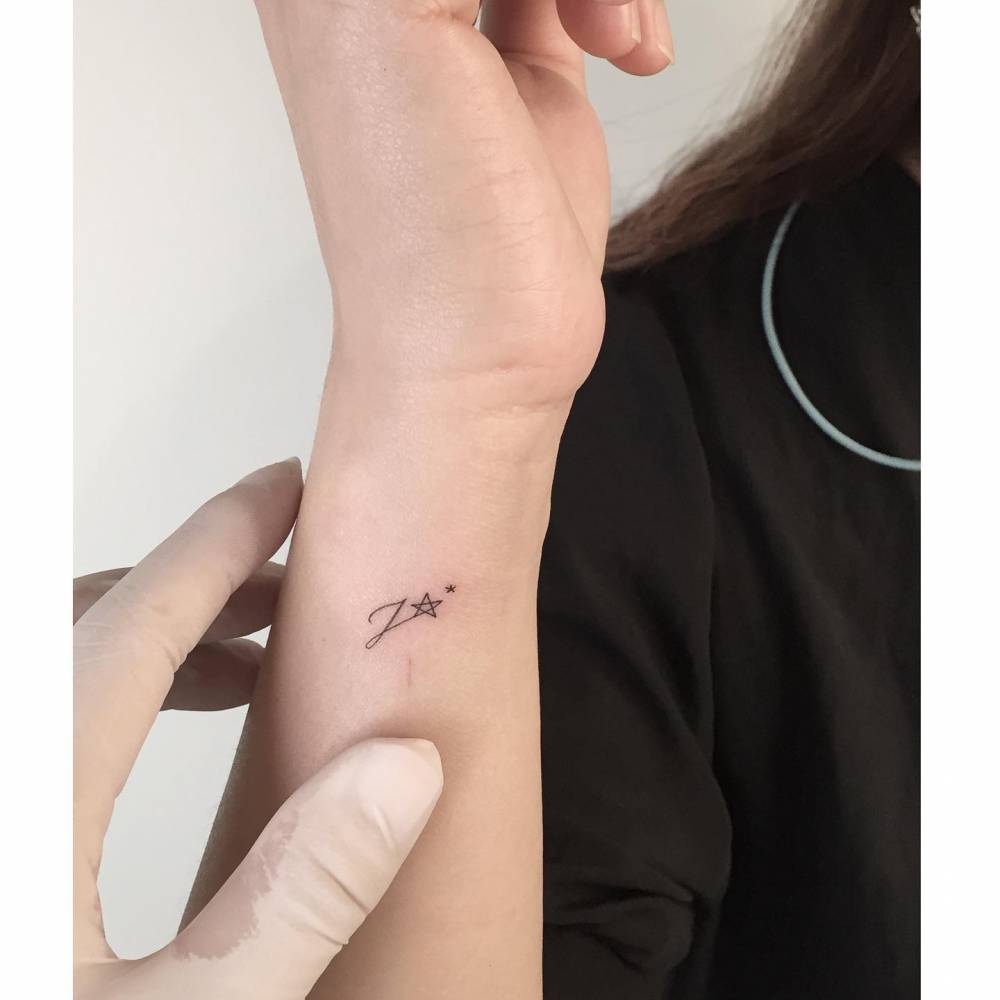 Tiny Initial And Star Tattoo Located On The Wrist 