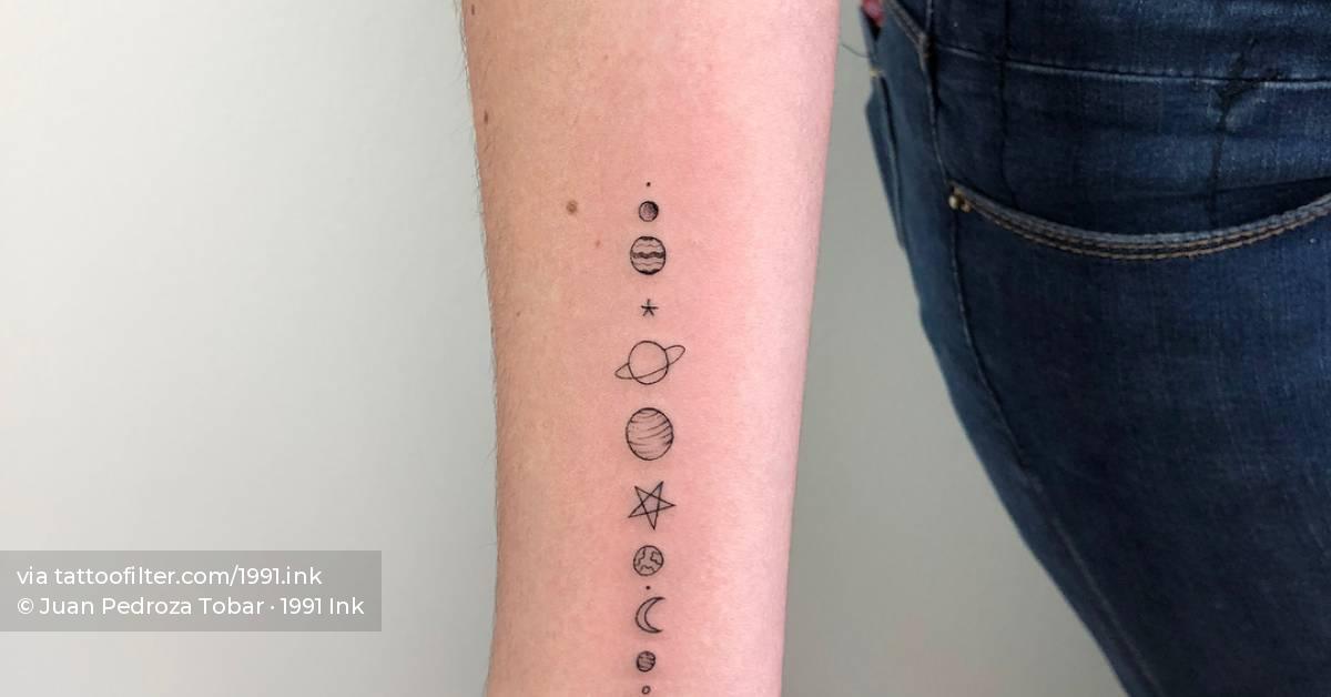 Minimalist solar system tattoo on the inner forearm