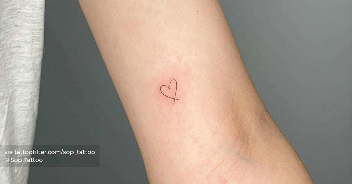 Tiny heart tattoo located on the inner arm.