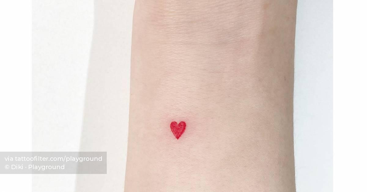 Minimalistic red heart tattoo located on the wrist.