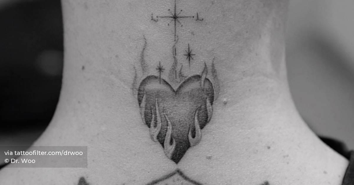 Single needle flaming heart tattoo located on the back