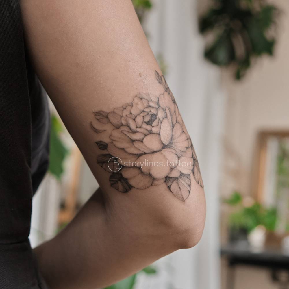 Single needle delicate tattoo of a peony.