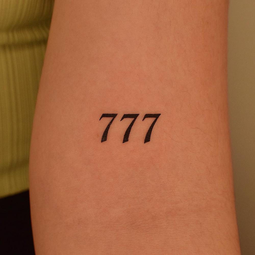 Tattoo Of The Number 777 Located On The Bicep 