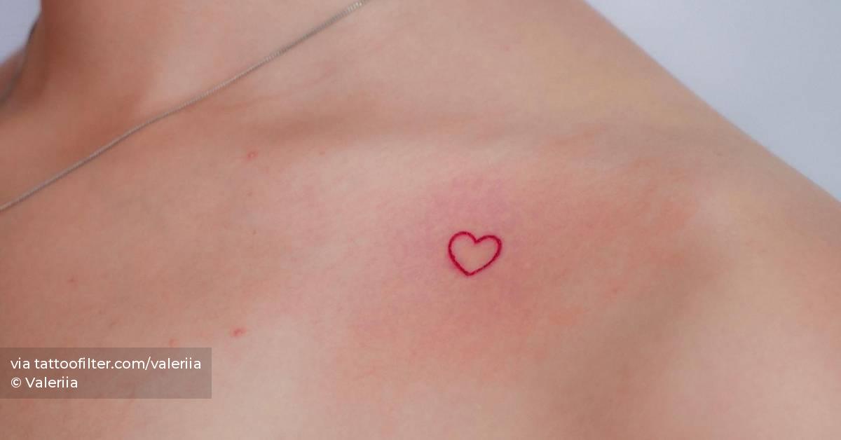 Minimalistic red heart tattoo located on the