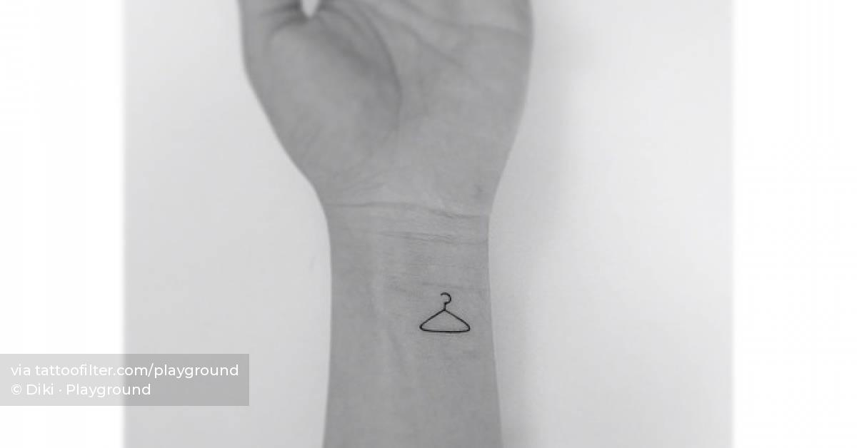 Minimalistic clothes hanger tattooed on the wrist.