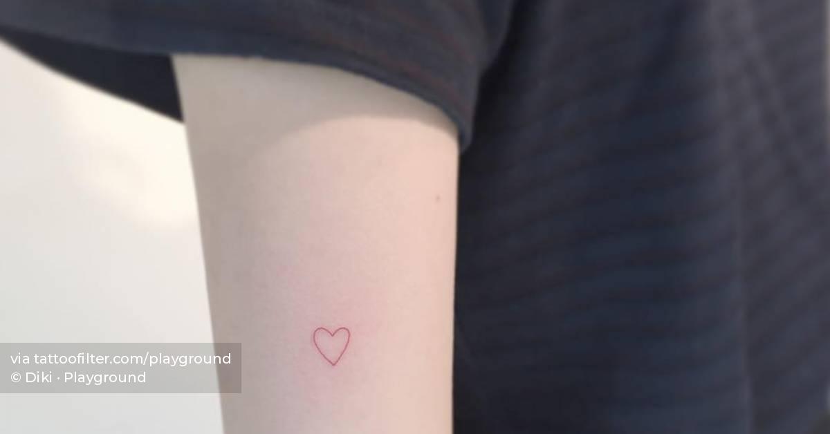 Red heart tattoo located on the tricep, minimalistic