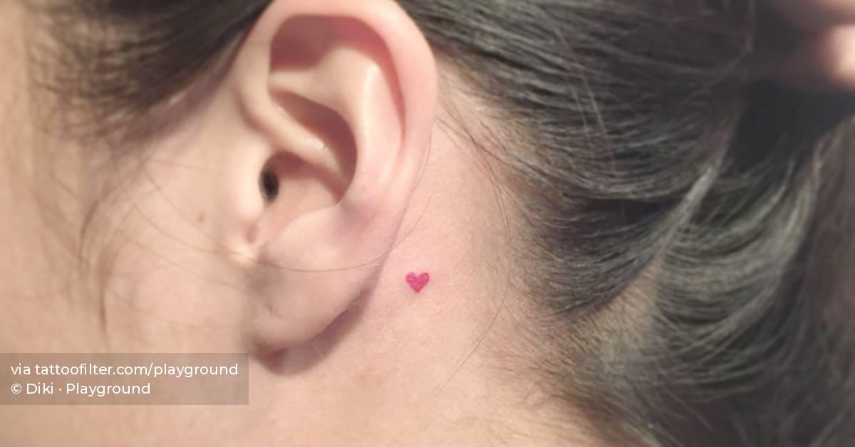 Micro red heart tattoo located behind the ear,