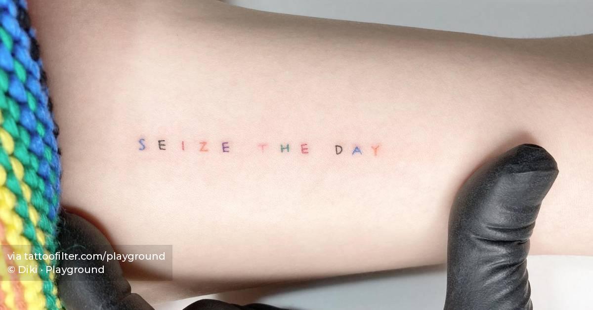 Colorful "seize the day" lettering tattoo located on