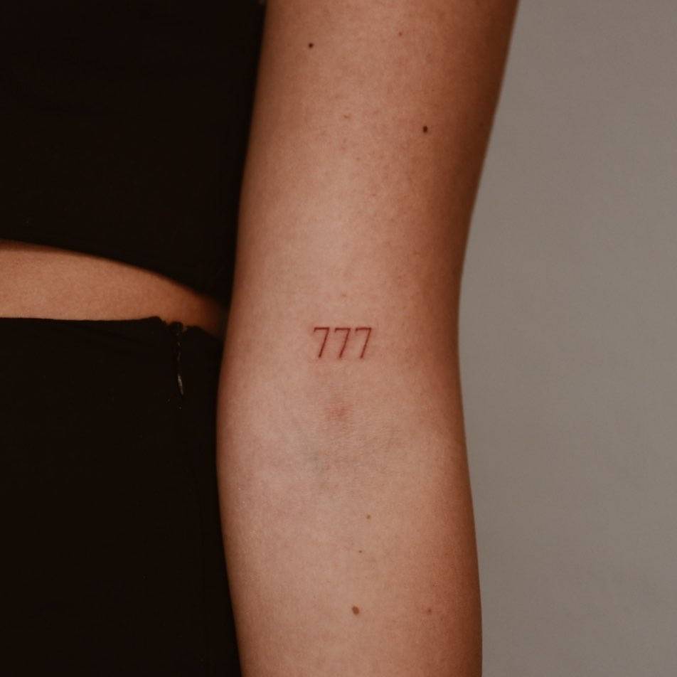 Number 777 Tattooed On The Bicep 