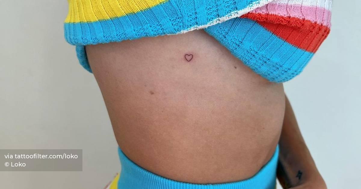 Tiny tattoo of a minimalistic heart located on the side