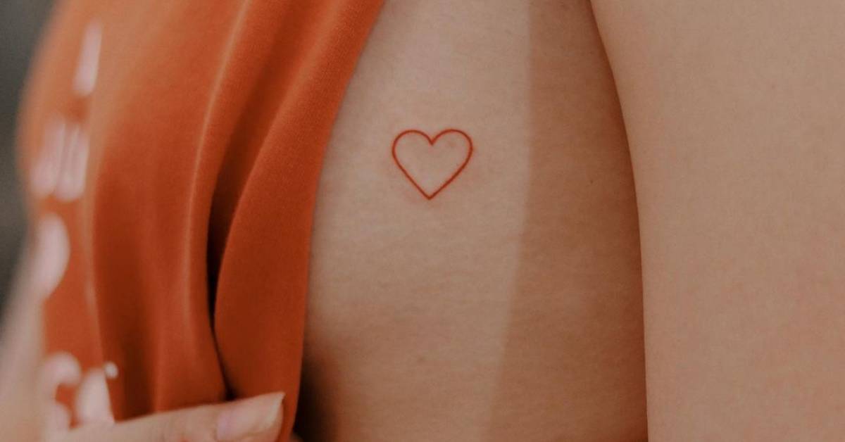 Minimalistic style red heart tattoo located on the side
