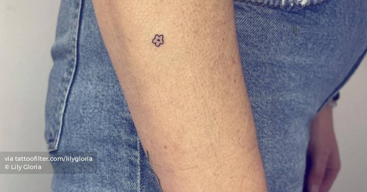 Micro flower tattoo hand poked on the forearm.