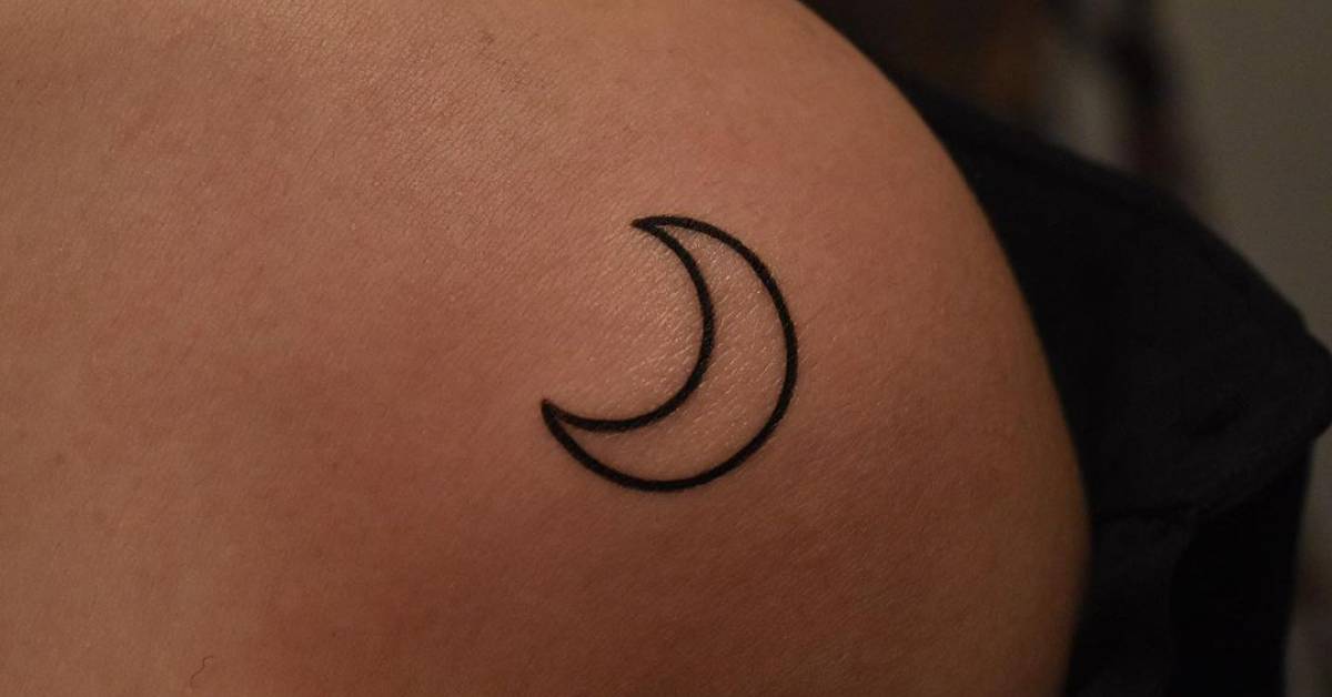 Minimalistic moon tattooed on the shoulder.