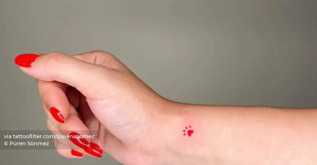Minimalistic style red dog paw tattoo located on the