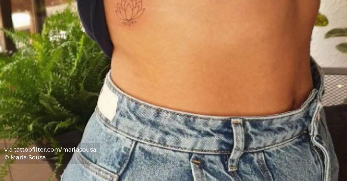 Fine line lotus flower tattoo on the rib.