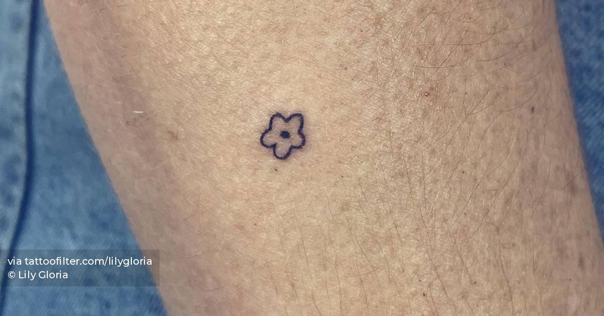 Micro flower tattoo hand poked on the forearm.