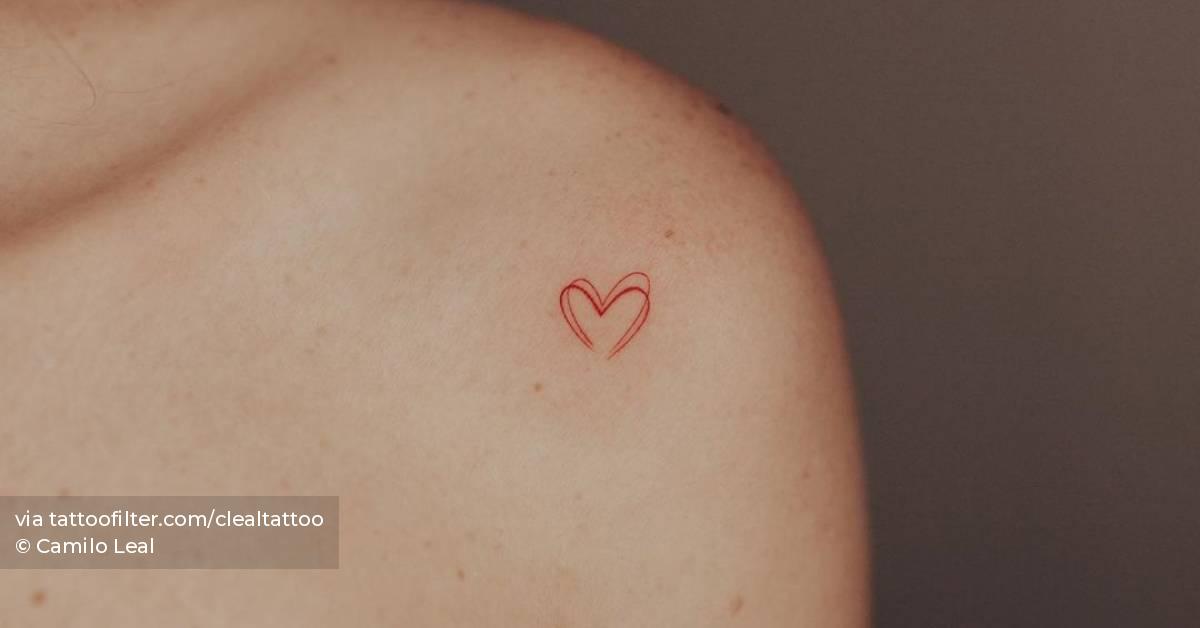 Minimalistic red heart tattoo located on the shoulder.