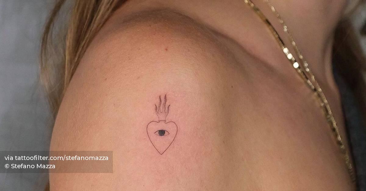 Tiny flaming heart tattoo located on the shoulder,