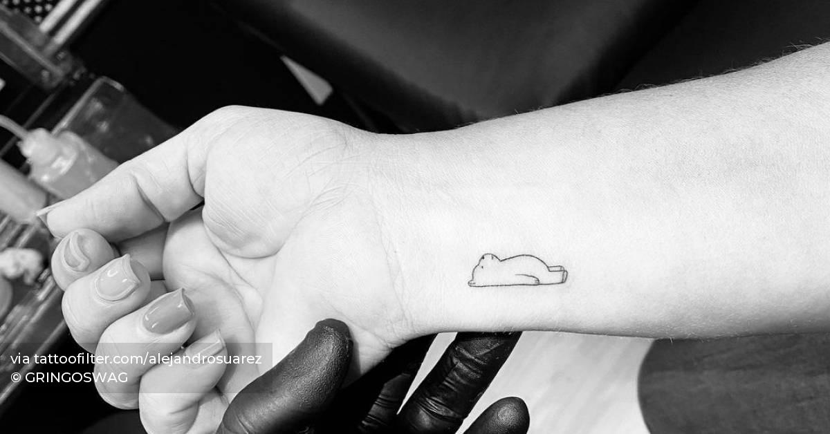 Tiny minimalistic bear tattoo located on the wrist.