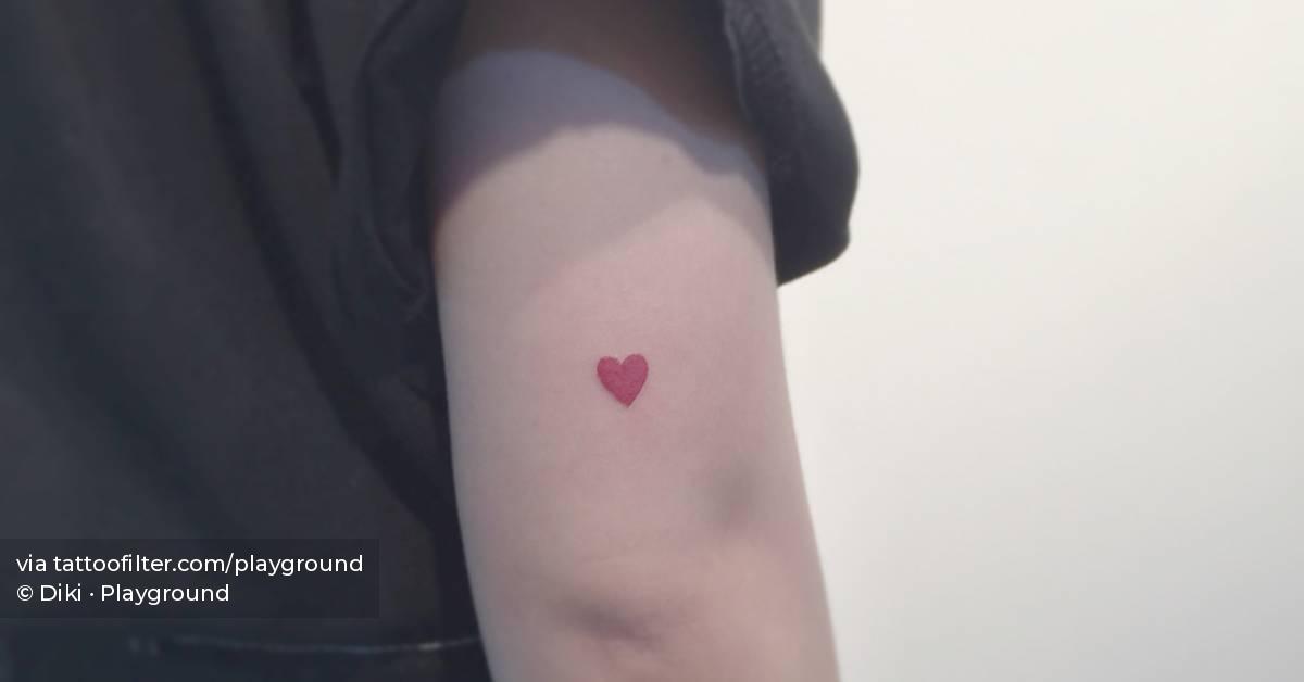 Red heart tattoo located on the tricep, minimalistic