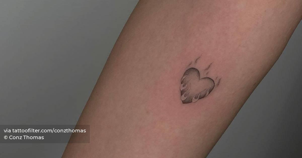 Single needle flaming heart tattoo located on the inner