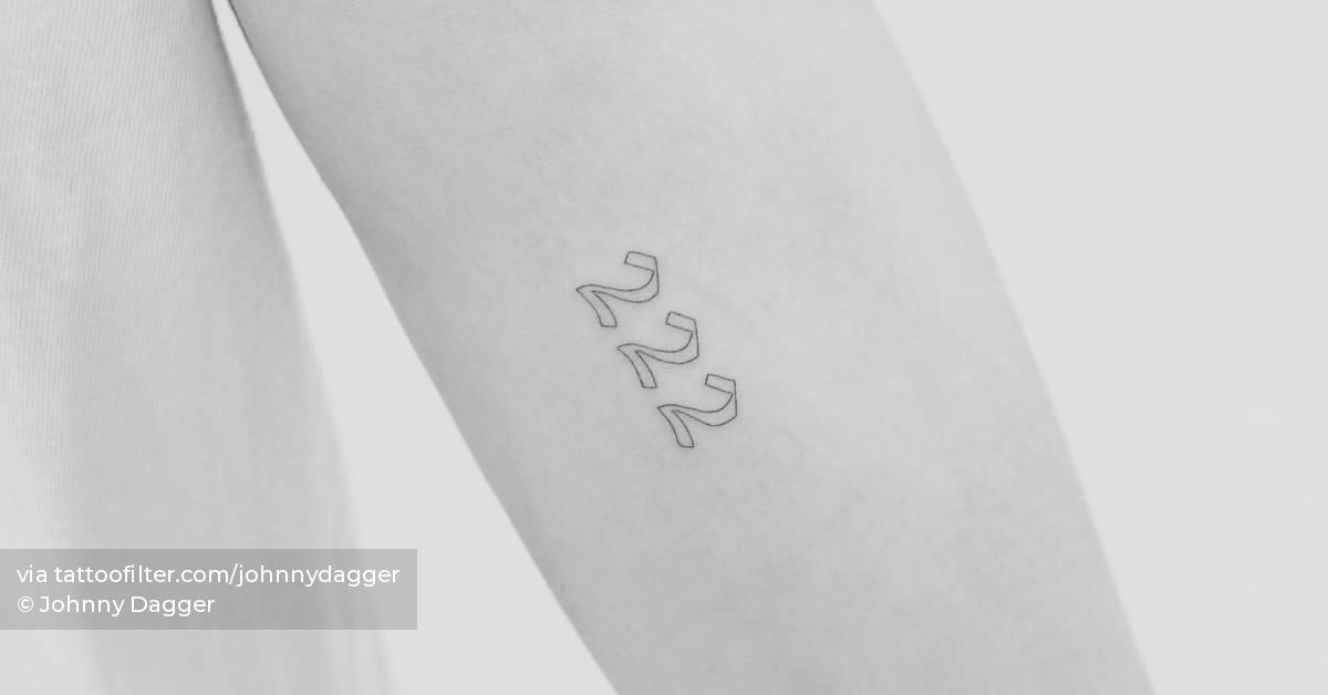 Angel number "222" tattooed on the inner forearm.